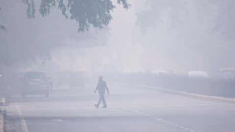 A man crosses a street in smoggy conditions in New Delhi on Monday, November 4, 2019. Millions of people in India's capital started the week choking through "eye-burning" smog, with schools closed, cars taken off the road and construction halted. (Jewel Samad/AFP via Getty Images)