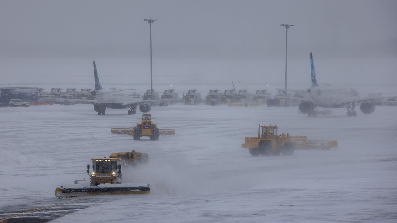 Snow plows work at John F. Kennedy International Airport in New York, the United States, Jan. 29, 2022. Winter storm Kenan is bringing heavy snow and wind gusts to New York City and surrounding areas on Saturday.   Snowfall at John F. Kennedy International Airport exceeded 5 inches in the last 12 hours, said a tweet from the National Weather Service at 9 a.m. on Saturday.   As much as 460 flights from John F. Kennedy International Airport were canceled accounting for 80 percent of the total, according to travel information platform flightaware.com. (Photo by Winston Zhou/Xinhua via Getty Images)