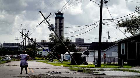 KENNER, LOUISIANA - AUGUST 30: A woman looks over damage to a neighborhood caused by Hurricane Ida on August 30, 2021 in Kenner, Louisiana. Ida made landfall yesterday as a category 4 storm southwest of New Orleans.  (Photo by Scott Olson/Getty Images)