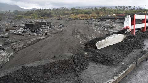 Mud surrounds a damaged bridge after heavy rains poured down and further battered areas already burdened by heavy ashfall from eruptions of La Soufriere volcano, in Kingstown, on the Caribbean island of St. Vincent, Thursday, April 29, 2021. (AP Photo/Orvil Samuel)