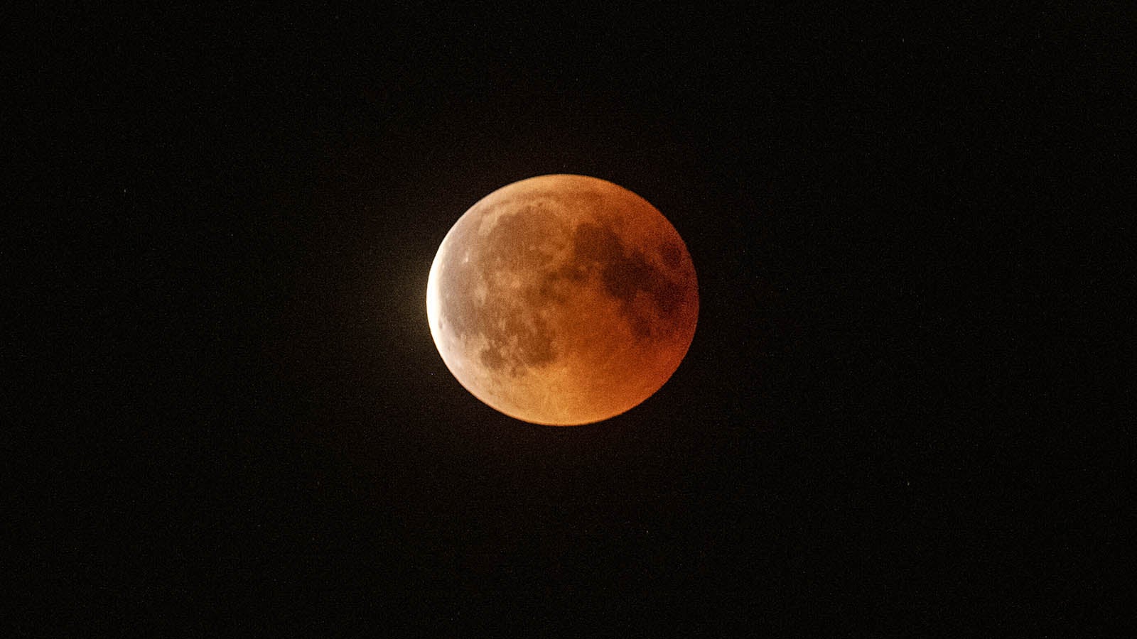 ARCHIV - 27.07.2018, Berlin: Rot leuchtet der Mond bei der totalen Mondfinsternis, w&auml;hrend langsam die Dunkelheit abnimmt. (zu dpa &laquo;Sonne, Mond und Sterne im Januar - Mondfinsternis und Sternschnuppen&raquo; vom 19.12.2018)