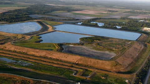 This aerial photo shows a reservoir near the old Piney Point phosphate plant, Saturday, April 3, 2021 in Bradenton, Florida. The reservoir sits in a stack of phosphogypsum, a waste product from manufacturing fertilizer. (Tiffany Tompkins/The Bradenton Herald via AP)