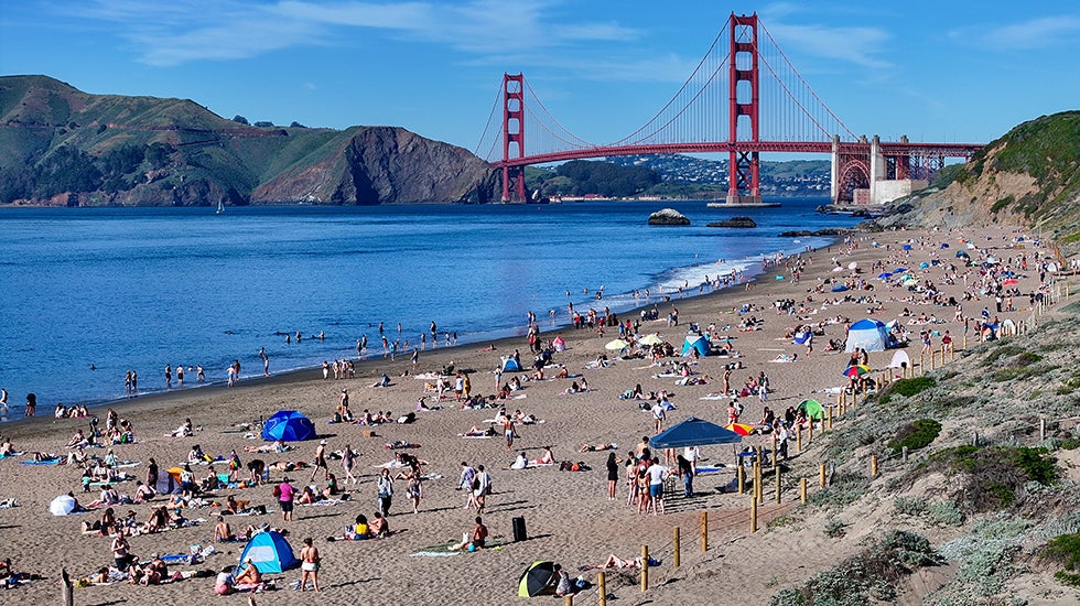 People flock to Baker Beach near the Golden Gate Bridge as a heat advisory was issued in San Francisco, California, on Monday, March 16, 2026. (Photo by Tayfun Coskun/Anadolu via Getty Images)