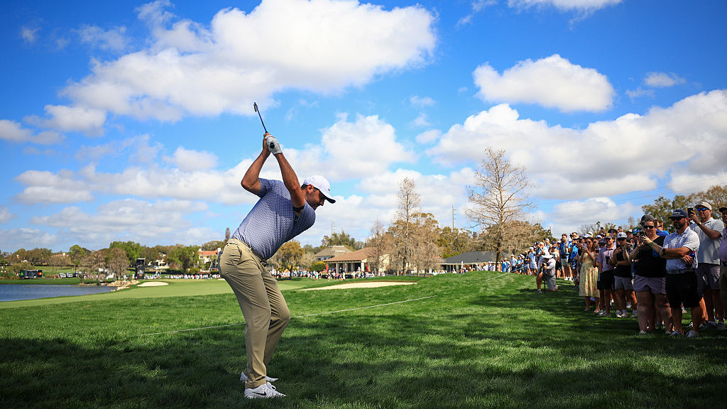 Scottie Scheffler of the United States plays an approach shot on the third hole as a gallery of fans look on during the first round of the Arnold Palmer Invitational presented by Mastercard 2026 at Arnold Palmer Bay Hill Golf Course on March 05, 2026 in Orlando, Florida. (Photo by Mike Ehrmann/Getty Images)