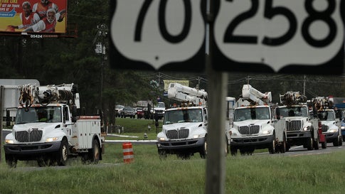 A fleet of utility bucket trucks drives along West New Bern Road on September 16, 2018, in Kinston, North Carolina, after Hurricane Florence. (Photo by Chip Somodevilla/Getty Images)