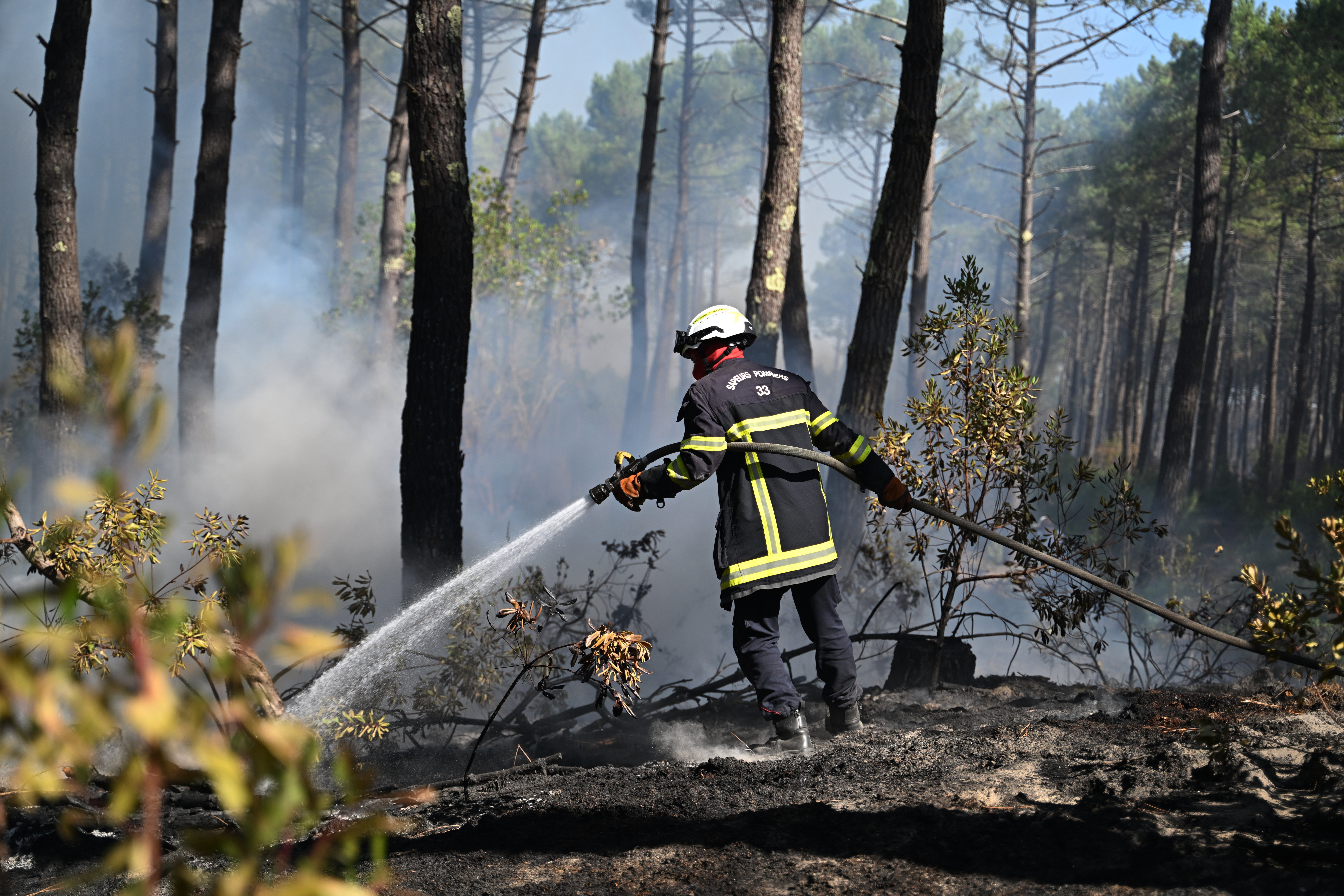 28.07.2026, Frankreich, Claouey: Ein Feuerwehrmann verteit Wasser in einem Waldst&uuml;ck bei Claouey. Feuer haben es in S&uuml;dwesteuropa zunehmend leicht, zum Flammen-Inferno zu werden. Foto: Emma Da Silva/AP/dpa +++ dpa-Bildfunk +++