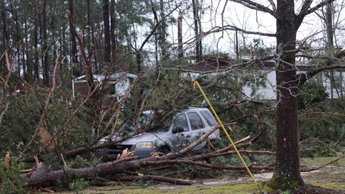 A vehicle is caught under downed trees along Lee Road 11 in Beauregard, Alabama, Sunday, March 3, 2019, after a powerful storm system passed through the area. (Kara Coleman Fields/Opelika-Auburn News via AP)