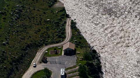 A road ends where floodwaters washed away a house in Gardiner, Mont., Thursday, June 16, 2022. Yellowstone officials are hopeful that next week they can reopen the southern half of the park, which includes Old Faithful geyser. Park officials say the northern half of the park, however, is likely to remain closed all summer, a devastating blow to the local economies that rely on tourism. (AP Photo/David Goldman)