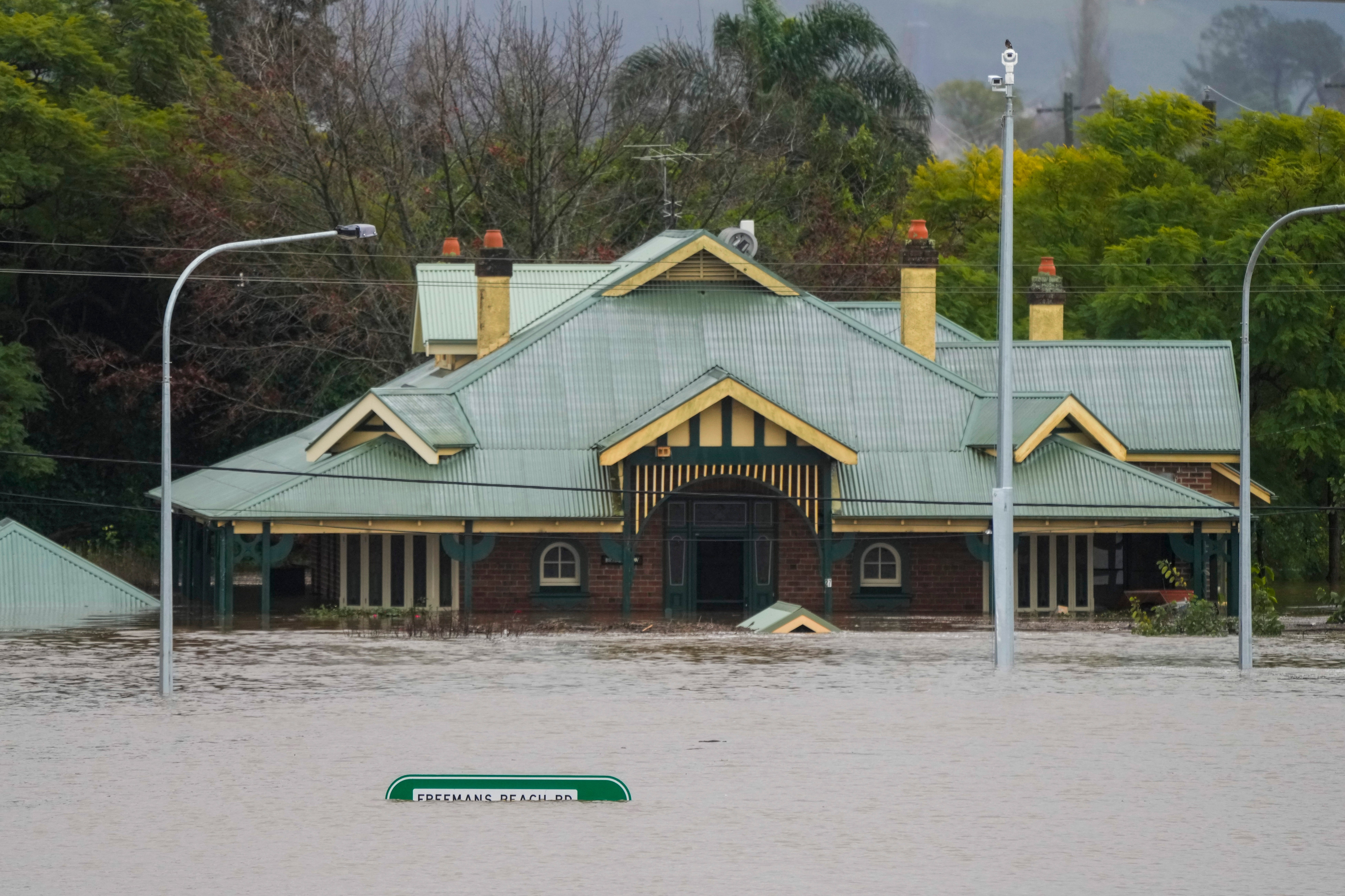 A building is inundated with water on the far side of the Windsor Bridge at Windsor on the outskirts of Sydney, Australia, Tuesday, July 5, 2022. Hundreds of homes have been inundated in and around Australia&rsquo;s largest city in a flood emergency that was impacting 50,000 people, officials said Tuesday.(AP Photo/Mark Baker)