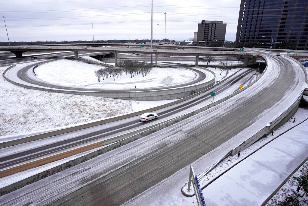A lone driver makes their way through icy road conditions at the LBJ 635 Freeway and North Dallas Tollway interchange, Tuesday, Jan. 31, 2023, in Dallas, Texas. (AP Photo/Tony Gutierrez)