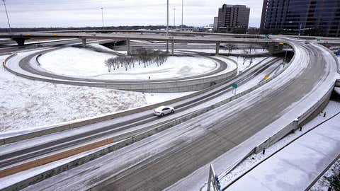 A lone driver makes their way through icy road conditions at the LBJ 635 Freeway and North Dallas Tollway interchange, Tuesday, Jan. 31, 2023, in Dallas, Texas. (AP Photo/Tony Gutierrez)