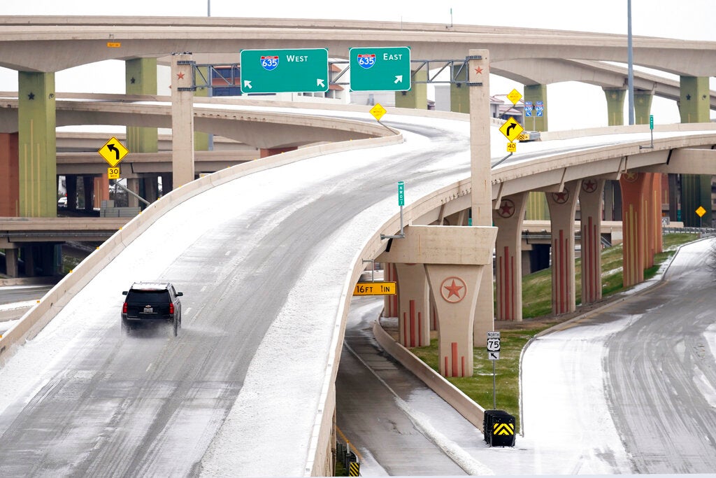 A driver slowly navigates through icy road conditions on the US 75 highway and LBJ 635 interchange Tuesday, Jan. 31, 2023, in Dallas. (AP Photo/Tony Gutierrez)