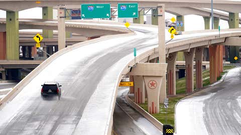 A driver slowly navigates through icy road conditions on the US 75 highway and LBJ 635 interchange Tuesday, Jan. 31, 2023, in Dallas. (AP Photo/Tony Gutierrez)