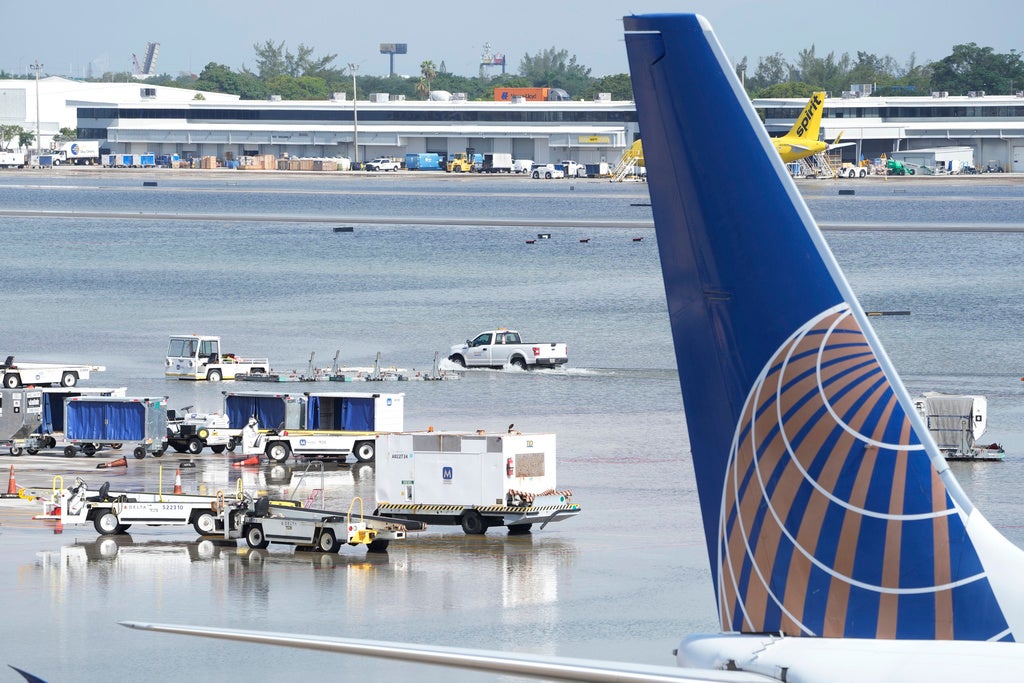 A truck drives on the flooded runway at Fort Lauderdale- Hollywood International Airport, Thursday, April 13, 2023, in Fort Lauderdale, Fla. Fort Lauderdale issued a state of emergency as flood conditions continued through many areas. Over 25 inches of rain fell in South Florida since Monday causing widespread flooding.(AP Photo/Marta Lavandier)