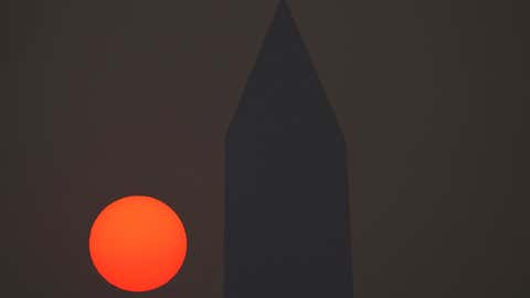 The sun rises behind the Washington Monument and a thick layer of smoke, Thursday, June 8, 2023, in Washington, D.C. Intense Canadian wildfires are blanketing the northeastern U.S. in a dystopian haze, turning the air acrid, the sky yellowish gray and prompting warnings for vulnerable populations to stay inside. (AP Photo/Julio Cortez)