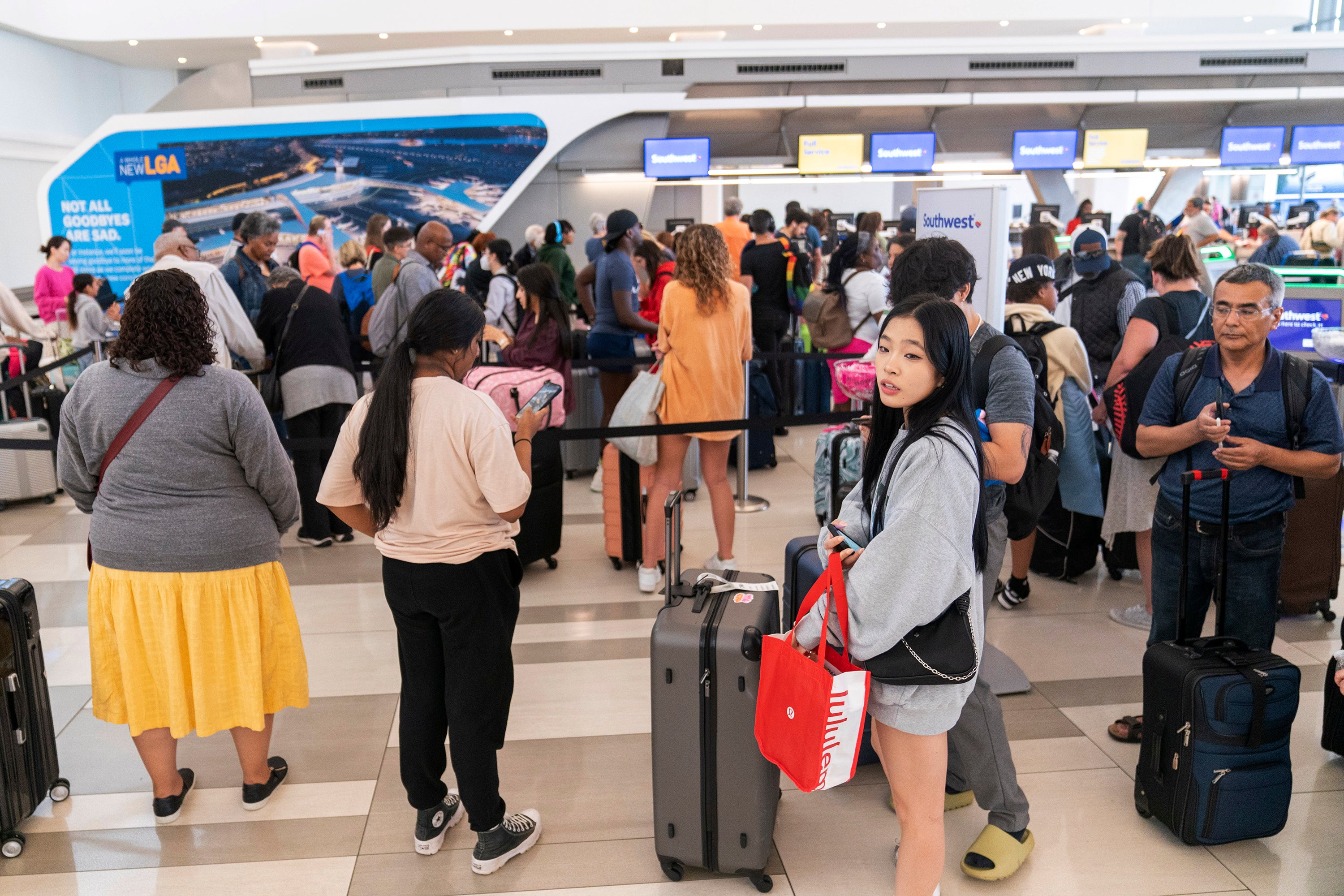 Travelers line up at the Southwest Airline ticket counter in the departures area of Terminal B at LaGuardia Airport, Tuesday, June 27, 2023, in New York.  Travelers waited out widespread delays at U.S. airports on Tuesday, an ominous sign heading into the long July 4 holiday weekend, which is shaping up as the biggest test yet for airlines that are struggling to keep up with surging numbers of passengers.(AP Photo/Mary Altaffer)