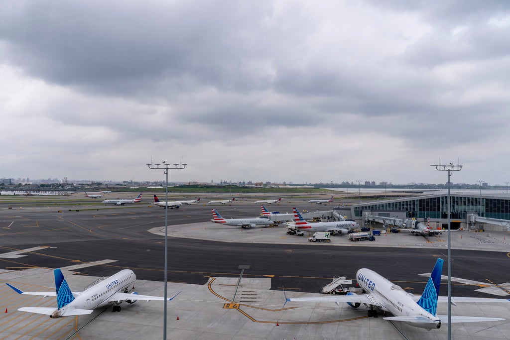 Storm clouds loom over airplane on the tarmac at LaGuardia Airport, Tuesday, June 27, 2023, in New York.  Travelers waited out widespread delays at U.S. airports on Tuesday, an ominous sign heading into the long July 4 holiday weekend, which is shaping up as the biggest test yet for airlines that are struggling to keep up with surging numbers of passengers. (AP Photo/Mary Altaffer)