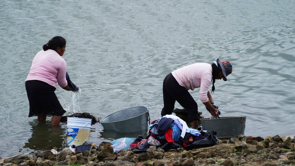 Locals wash clothes on the banks of the Villa Victoria reservoir in the the State of Mexico, Tuesday, Oct. 10, 2023. The capital’s reservoirs like Villa Victoria are running historically low following a “too dry” summer, according to official data, and as the rainy season draws to a close, water restrictions have already begun. (AP Photo/Marco Ugarte)