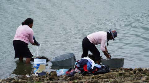 Locals wash clothes on the banks of the Villa Victoria reservoir in the the State of Mexico, Tuesday, Oct. 10, 2023. The capital’s reservoirs like Villa Victoria are running historically low following a “too dry” summer, according to official data, and as the rainy season draws to a close, water restrictions have already begun. (AP Photo/Marco Ugarte)