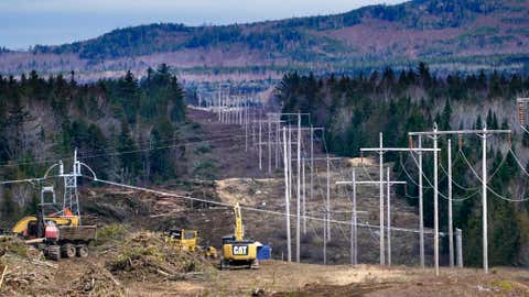 Heavy machinery is used to cut trees to widen an existing Central Maine Power power line corridor to make way for new utility poles, April 26, 2021, near Bingham, Maine. The International Energy Agency said in a report Tuesday that the capacity to connect to and transmit electricity isn't keeping pace with the rapid growth of clean energy technology like solar and wind power, electric cars and heat pumps. (AP Photo/Robert F. Bukaty, File)