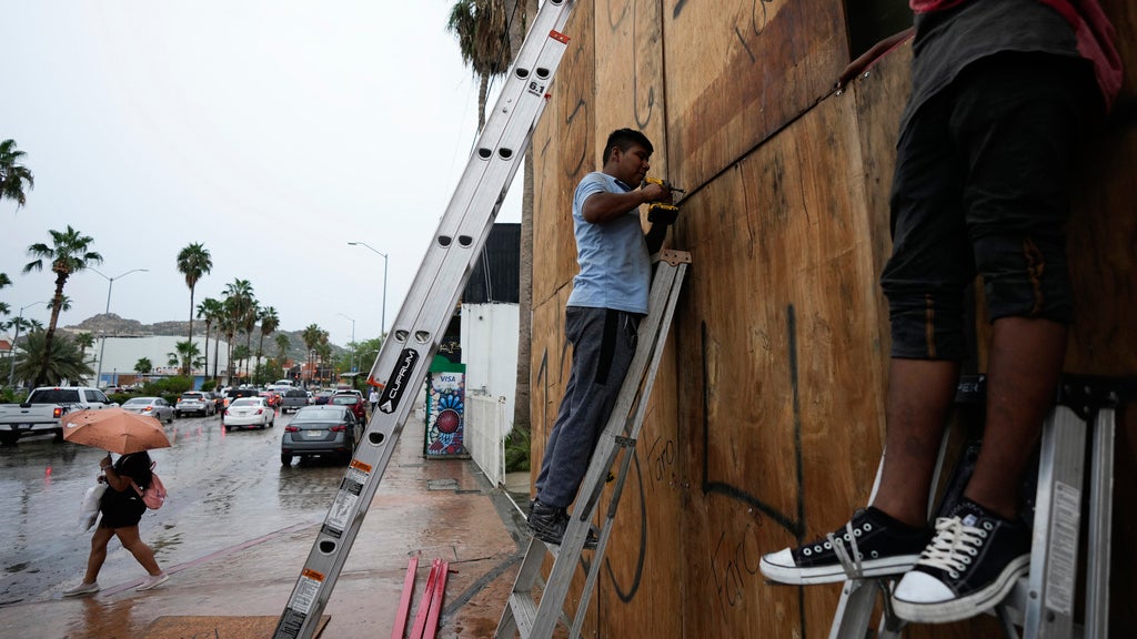 Employees cover the windows of a souvenirs store with wood in preparation for the arrival of the hurricane Norma, in Cabo San Lucas, Mexico, Friday, Oct. 20, 2023. Hurricane Norma is heading for the resorts of Los Cabos at the southern tip of Mexico's Baja California Peninsula, while Tammy grew into a hurricane in the Atlantic. (AP Photo/Fernando Llano)