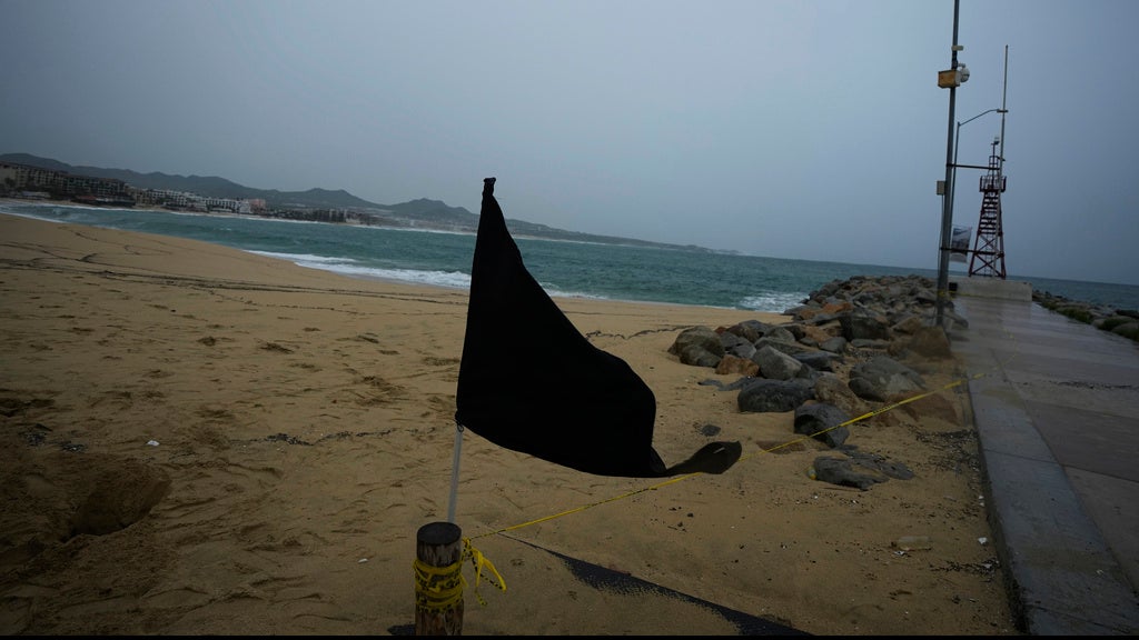 A black flag waves in the wind, signaling a closed beach, prior the arrival of the hurricane Norma in Cabo San Lucas, Mexico, Friday, Oct. 20, 2023. Hurricane Norma is heading for the resorts of Los Cabos at the southern tip of Mexico's Baja California Peninsula, while Tammy grew into a hurricane in the Atlantic. (AP Photo/Fernando Llano)