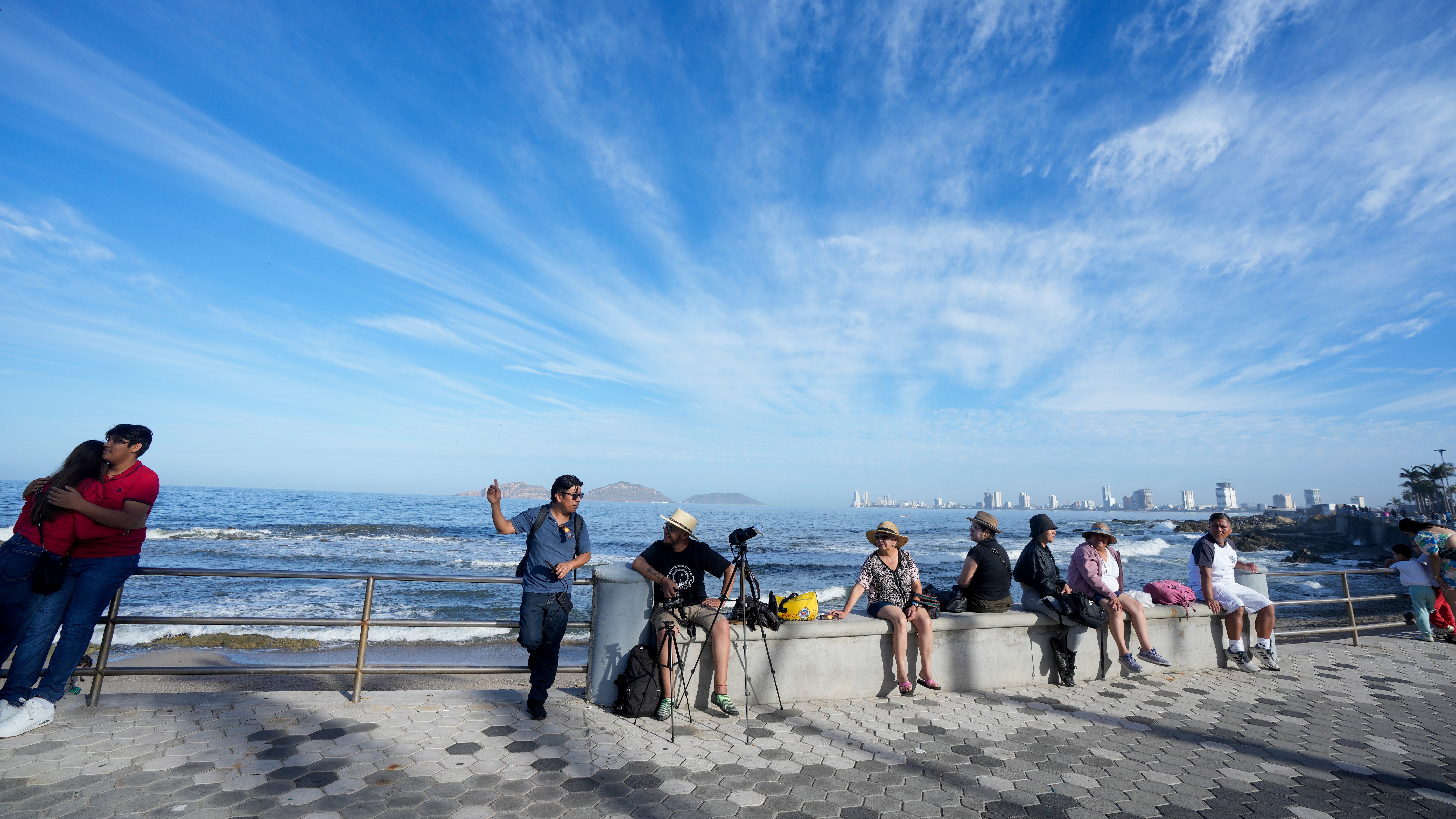 People wait to watch a total solar eclipse in Mazatlan, Mexico, Monday, April 8, 2024. (AP Photo/Fernando Llano)