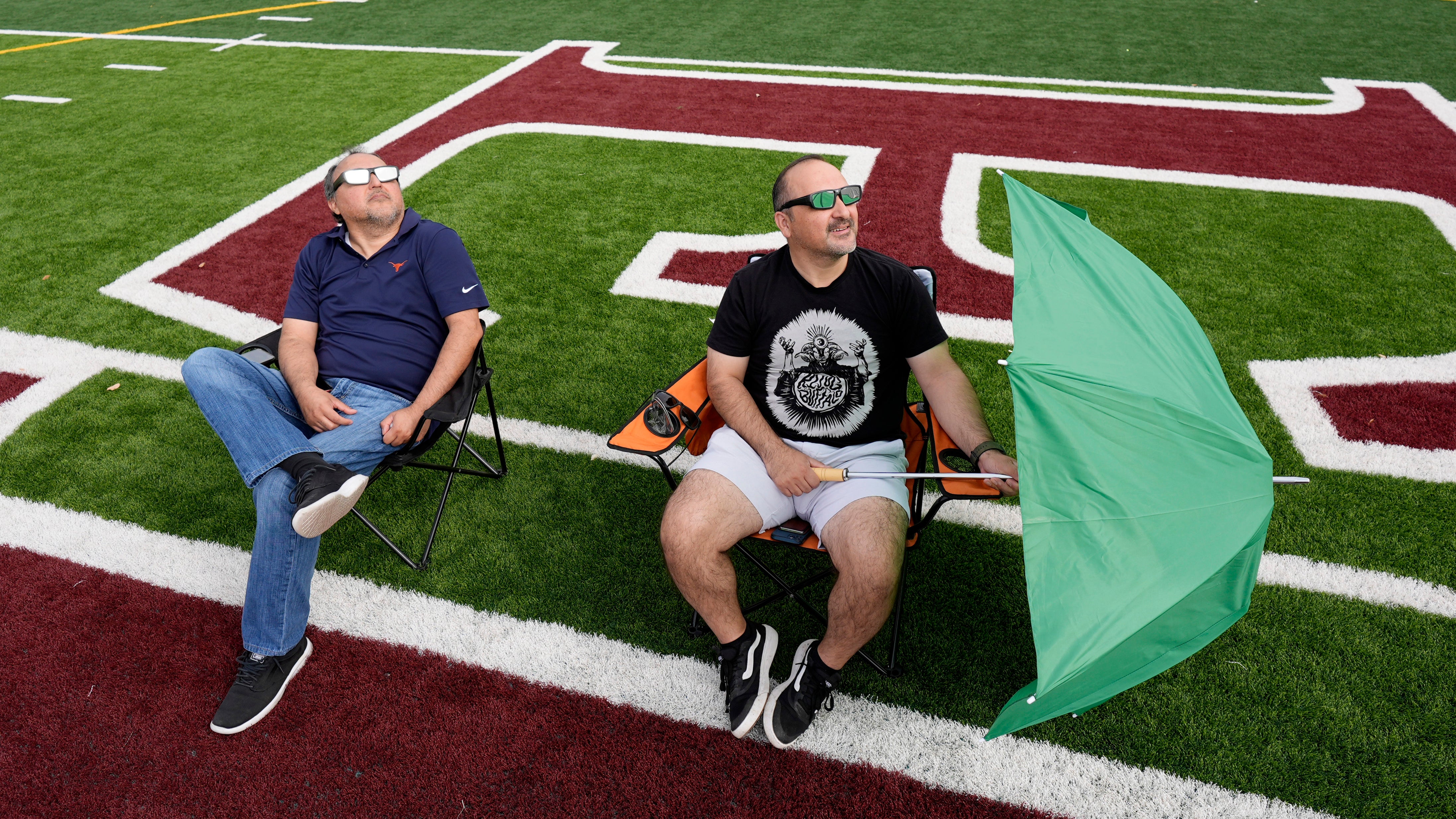 Joe and Ric Solis use special glasses as they prepare to watch a total solar eclipse in Eagle Pass, Texas, Monday, April 8, 2024. (AP Photo/Eric Gay)