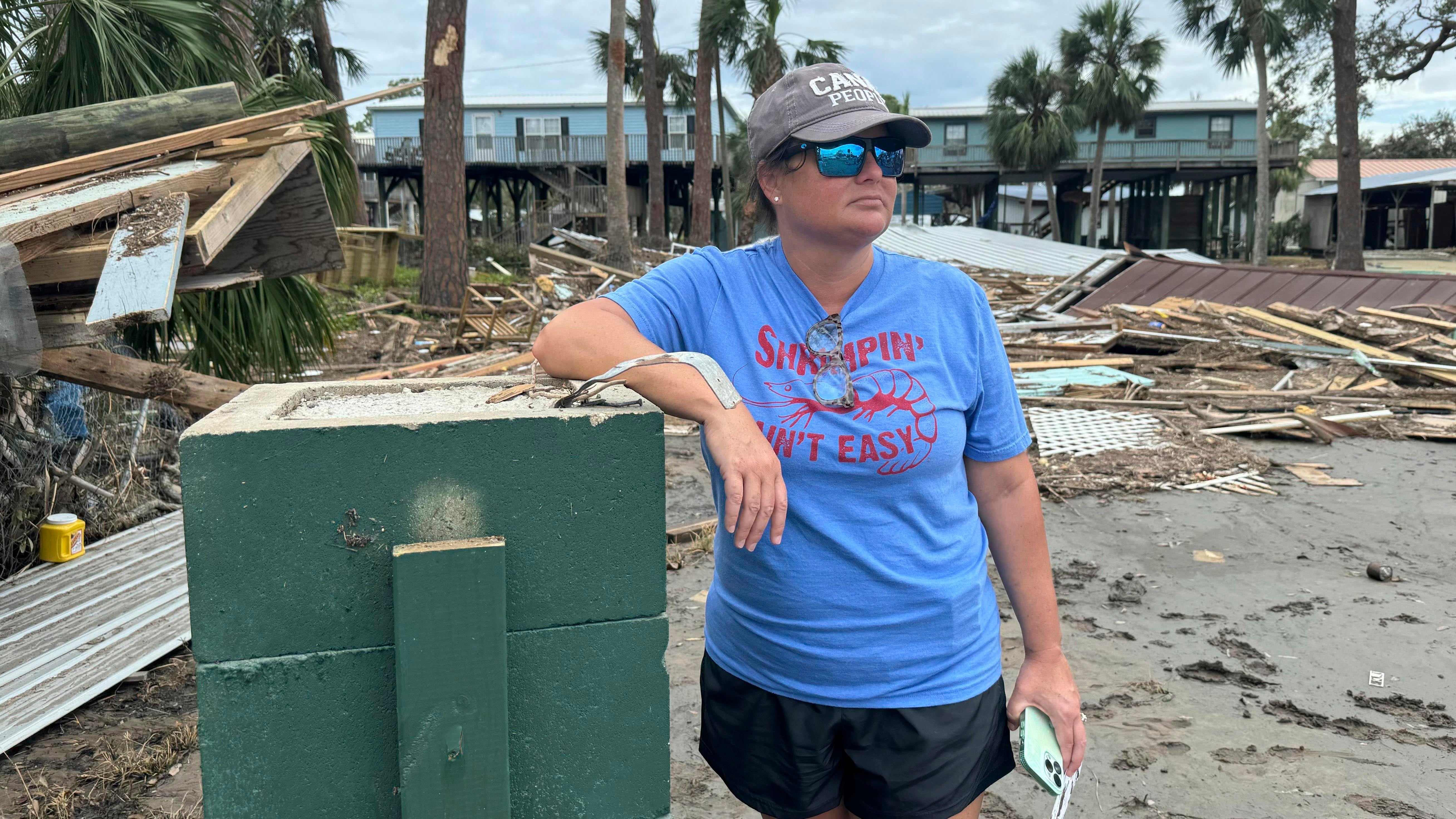 Brooke Hiers stands in front of where her home used to sit in Horseshoe Beach, Fla., Monday, Sept. 30, 2024, in the aftermath of Hurricane Helene. She and her husband had just rebuilt the home after Hurricane Idalia hit in August, 2023, before Hurricane Helene blew the house off its pilings and floated it into the neighbor's yard next door. (AP Photo/Kate Payne) 