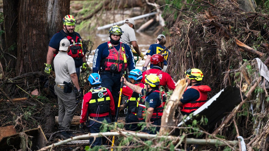 Firefighters from Ciudad Acuna, Mexico, left, aid in search and rescue efforts near the Guadalupe River days after a flash flood swept through the area, Monday, July 7, 2025, in Ingram, Texas. (AP Photo/Eli Hartman)