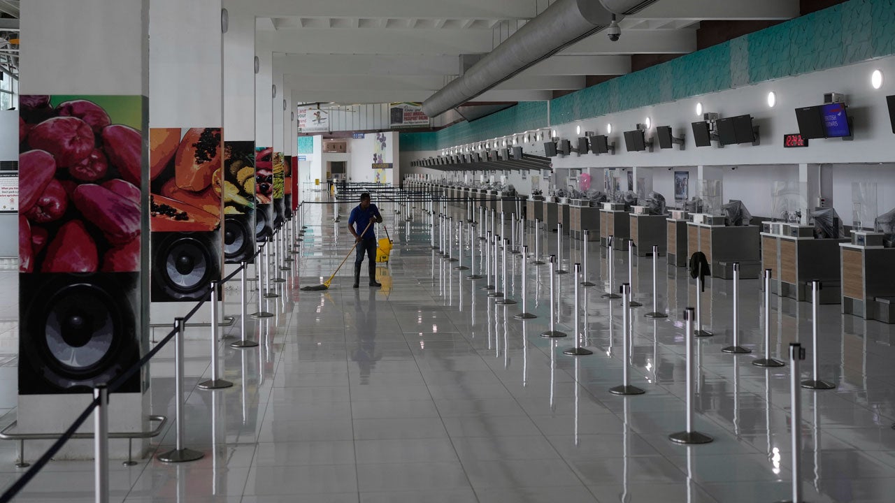 A janitor mops the floor at Norman Manley International Airport, closed ahead of the forecast arrival of Hurricane Melissa, in Kingston, Jamaica, Sunday, Oct. 26, 2025. (AP Photo/Matias Delacroix)