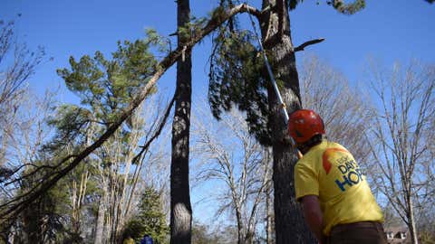 Clint Oldfield, a volunteer with Eight Days of Hope, cuts down a tree limb on Friday, Feb. 6, 2026 in Oxford, Ms. (AP Photo/Sophie Bates)