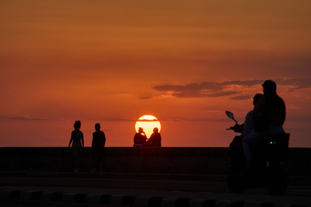 People spend the afternoon on the Malec&oacute;n at sunset, in Havana, Wednesday, Feb. 18, 2026. (AP Photo/Ramon Espinosa)