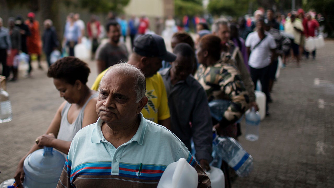 Residents queue to fill containers with water from a source of natural spring water in Cape Town, South Africa, Friday, Feb. 2, 2018. South Africa's drought-hit city of Cape Town introduced new water restrictions in an attempt to avoid what it calls "Day Zero," the day in mid-April when it might have to turn off most taps. (AP Photo/Bram Janssen)