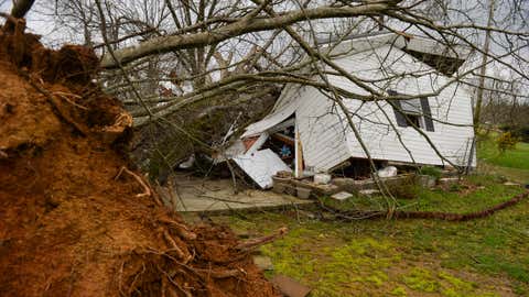 Fallen trees rest atop Andryne Penn's unattached garage, Tuesday, March 20, 2018, in Danville, Ala., after a violent storm went swept through the area the night before. Penn lost several large trees. The house was undamaged except for an unattached garage that was crushed by a fallen tree. (Crystal Vander Weit/The Decatur Daily via AP)