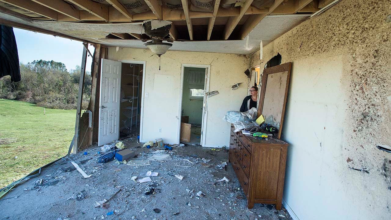 Shelly Cooper looks out into what was her guest bedroom in Elon, Va., Tuesday, April 17, 2018, a few days after a severe storm went through central Virginia. About 4,600 customers remained without power Tuesday morning, days after a tornado ripped through parts of central Virginia. (Jay Westcott/The News & Advance via AP)