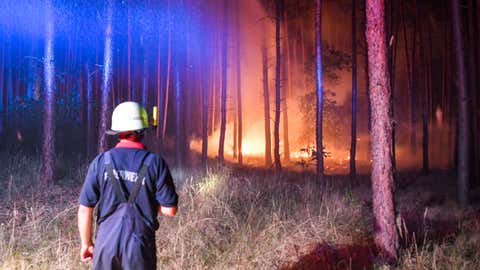 Firefighters battle a wildfire near the village of Klausdorf, about 50 miles south of Berlin, on Friday, Aug. 24, 2018. (Patrick Pleul/dpa via AP)