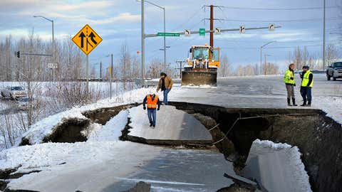 In this Friday, Nov. 30, 2018 file photo, workers inspect a road that collapsed during an earthquake in Anchorage, Alaska. The collapsed roadway that became an iconic image of the destructive force of a magnitude 7.0 earthquake and its aftershocks was repaired just days after the quake. The off-ramp connecting Minnesota Drive and Ted Stevens Anchorage International Airport reopened Tuesday, Dec. 4, 2018, with shoulder work completed Wednesday. (AP Photo/Mike Dinneen, File)