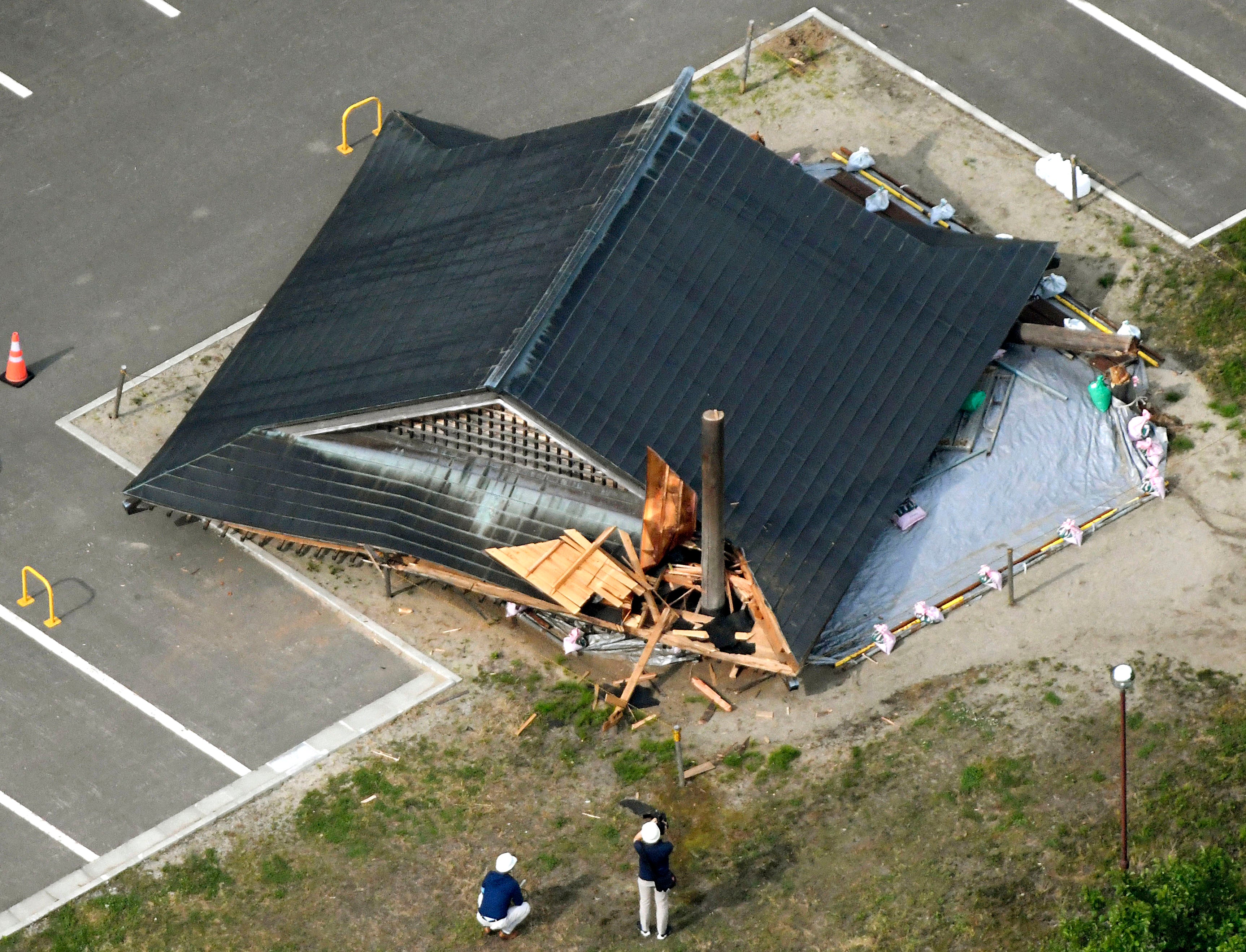 The roof of the wooden sumo building falls on the site of the Oizumi Elementary School in Tsuruoka, Yamagata prefecture, northwestern Japan, Wednesday, June 19, 2019, after an earthquake. The powerful earthquake jolted northwestern Japan late Tuesday, prompting officials to issue a tsunami warning along the coast which was lifted about two and a half hours later. Tsuruoka city officials were helping coastal residents evacuate to higher ground as a precaution. (Kyodo News via AP)