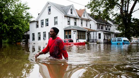 Chris Smith makes his way through floodwaters to the Macedonia Baptist Church in Westville, N.J., Thursday, June 20, 2019. Severe storms containing heavy rains and strong winds spurred flooding across southern New Jersey, disrupting travel and damaging some property. (AP Photo/Matt Rourke)