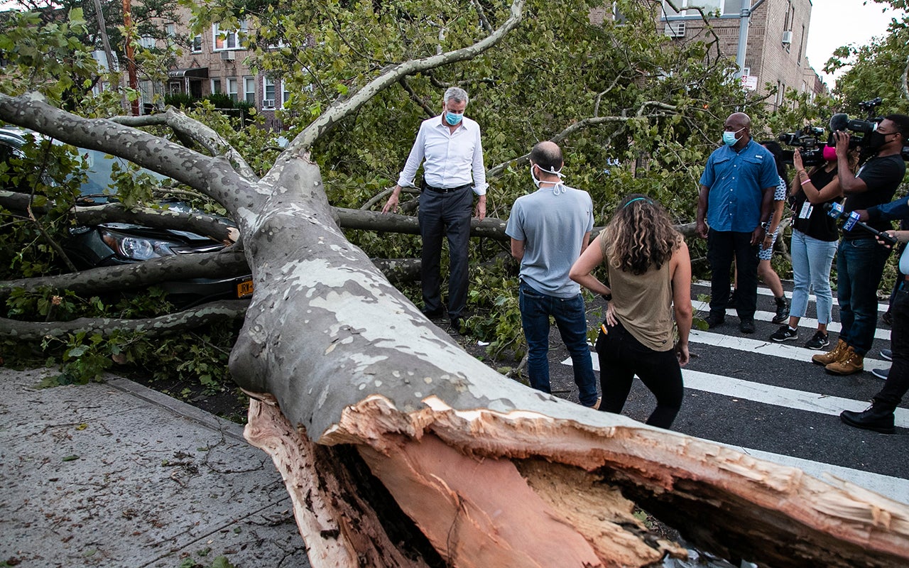 New York City Mayor Bill de Blasio talks with residents about damage from Tropical Storm Isaias, Tuesday, Aug. 4, 2020, in the Queens borough of New York. (AP Photo/Frank Franklin II)