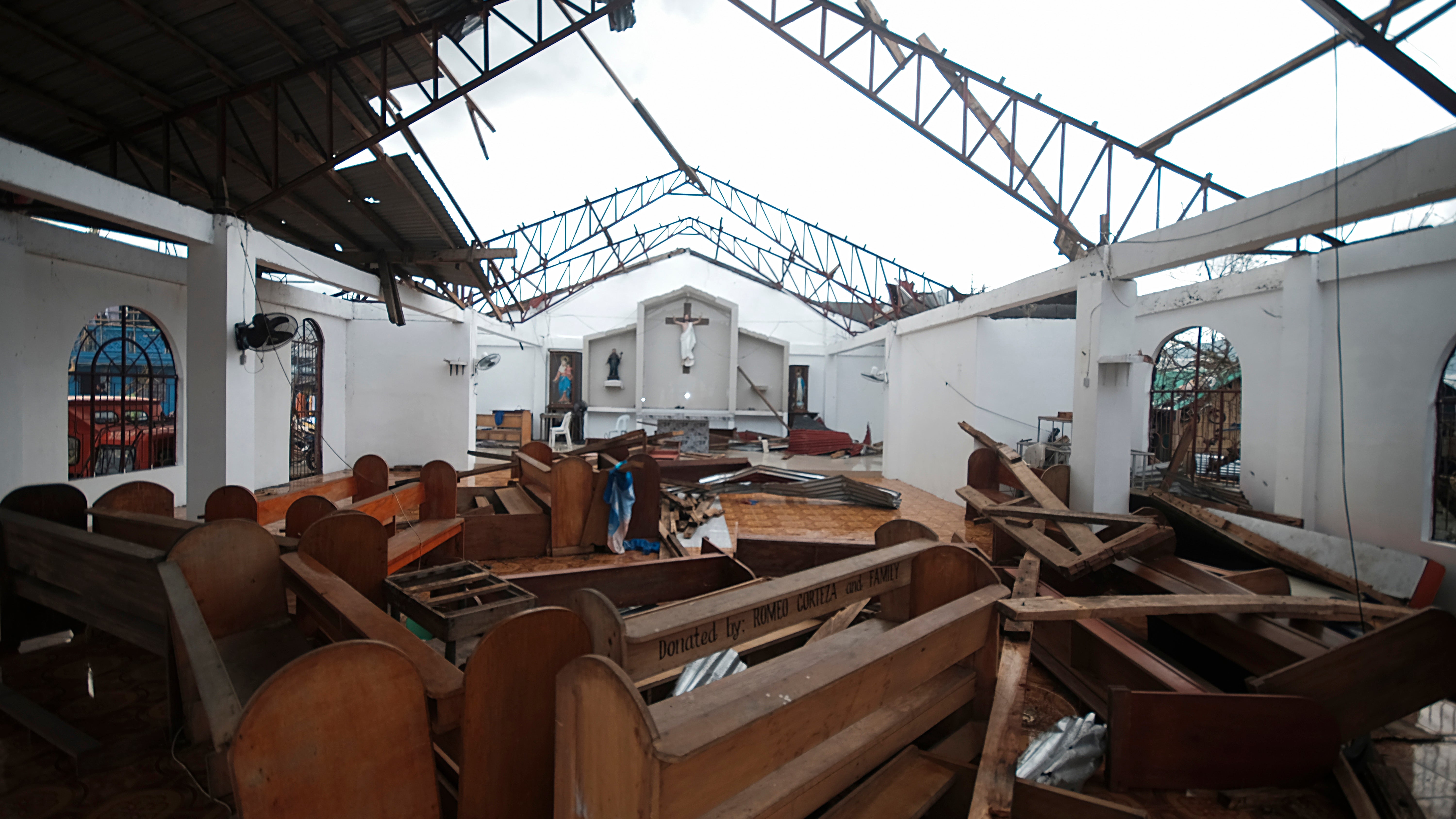The roof and pews of the St. Francis of Assisi church in Malinao town are damaged from powerful winds of Typhoon Goni in Albay province, central Philippines, on Tuesday Nov. 3, 2020. More than a dozen people were killed as Typhoon Goni lashed the Philippines over the weekend, and about 13,000 shanties and houses were damaged or swept away in the eastern island province that was first hit by the ferocious storm, officials said. (AP Photo/John Michael Magdasoc)