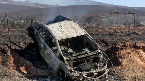 A charred car is seen on the burned area during the Bond Fire burns in Silverado, Calif., on Thursday, Dec. 3, 2020. (AP Photo/Ringo H.W. Chiu)