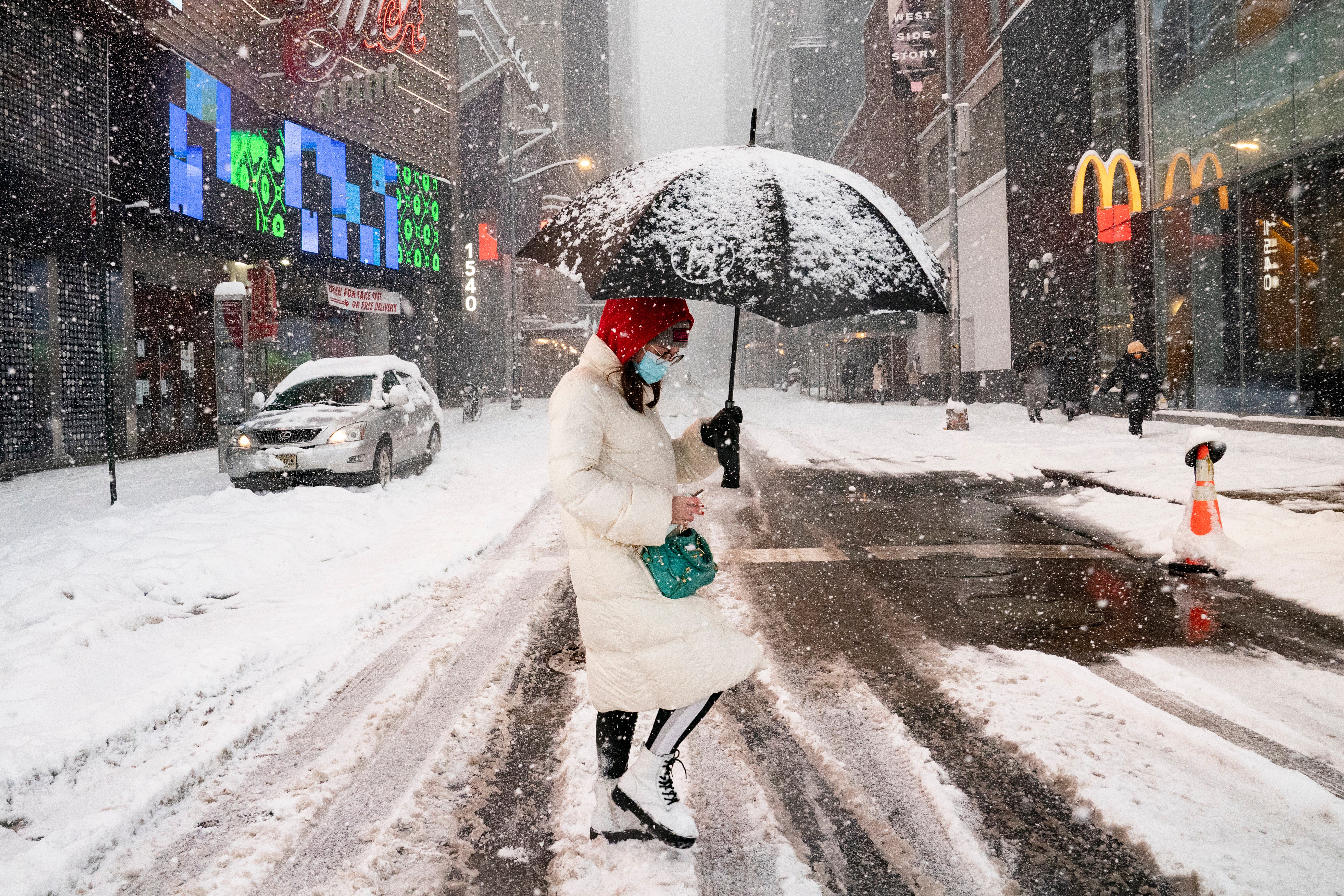 A woman walks through Times Square during a snowstorm, Monday, Feb. 1, 2021, in the Manhattan borough of New York. (AP Photo/John Minchillo)