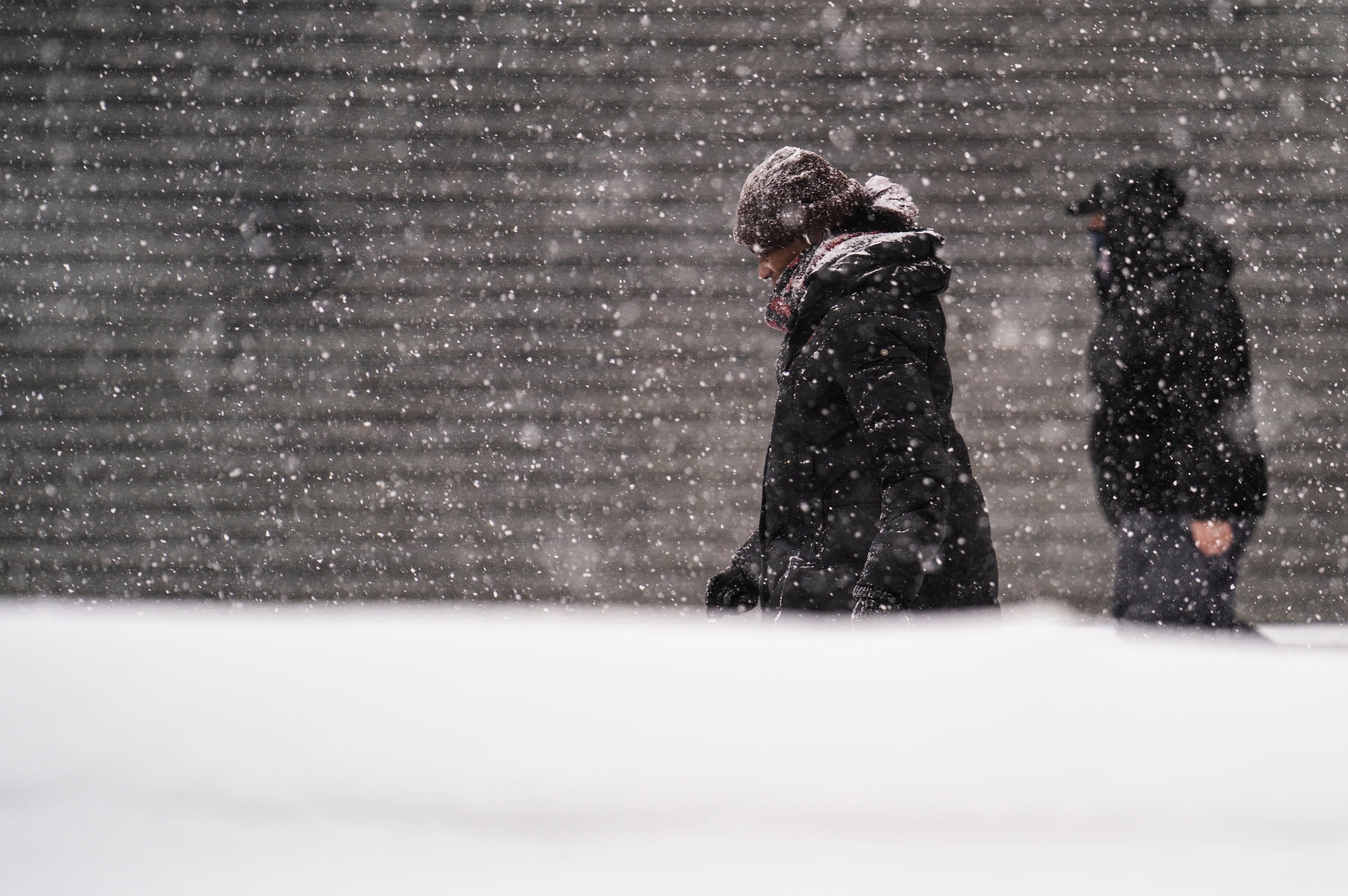 Pedestrians pass snow drifts and shuttered businesses during a snowstorm on Broadway, Monday, Feb. 1, 2021, in the Manhattan borough of New York. (AP Photo/John Minchillo)