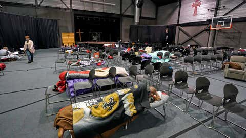 People seeking shelter from below freezing temperatures rest inside a church warming center Tuesday, Feb. 16, 2021, in Houston. More than 4 million people in Texas still had no power a full day after historic snowfall and single-digit temperatures created a surge of demand for electricity to warm up homes unaccustomed to such extreme lows, buckling the state's power grid and causing widespread blackouts. (AP Photo/David J. Phillip)