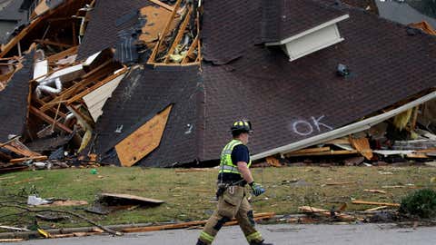 A firefighter surveys damage to a house after a tornado touches down south of Birmingham, Ala., in the Eagle Point community damaging multiple homes. The National Weather Service issued multiple tornado warnings for Alabama and surrounding states. (AP Photo/Butch Dill)