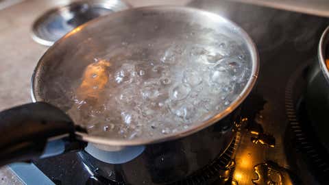 Cette photo représente une casserole d'eau bouillante, en cuisine, sur des plaques à induction. (Capelle.r/Getty Images)