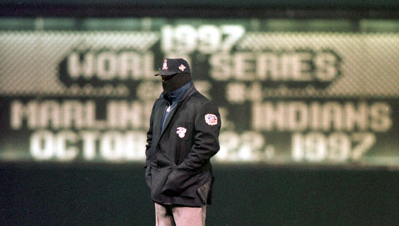 Second base umpire Ken Kaiser bundles up against the near freezing temperatures during the first inning of game 4 of the World Series featuring the Cleveland Indians against the Florida Marlins at Jacobs Field in Cleveland, OH, 22 October.  This is the coldest World Series game on record.  AFP PHOTO/Jeff HAYNES (Photo by JEFF HAYNES / AFP)        (Photo credit should read JEFF HAYNES/AFP via Getty Images)