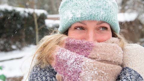 Woman in snow with large scarf and hat